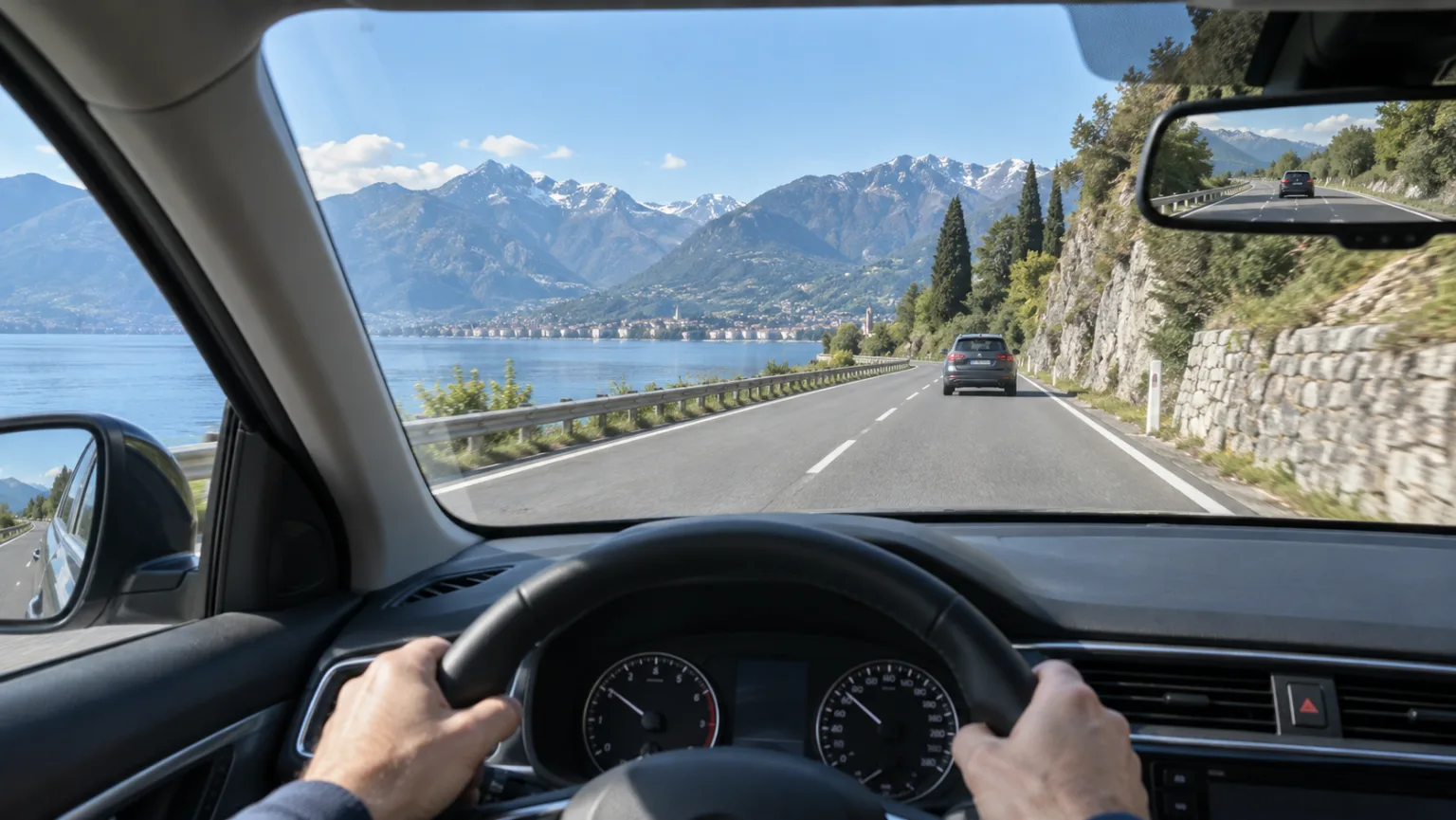 Interior de un coche con parabrisas, retrovisor y mandos visibles