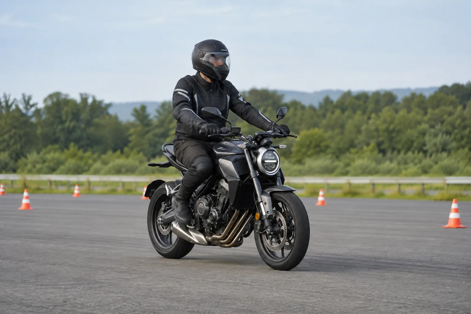 Motociclista con equipo de protección adopta una postura relajada en una pista de prácticas